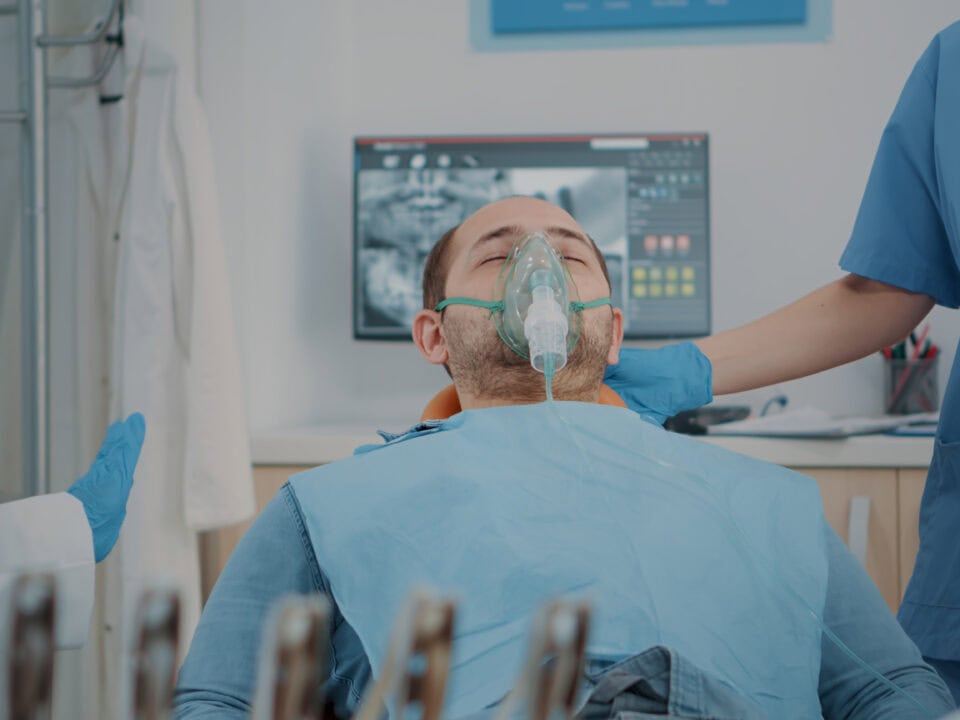 Patient with oxygen mask receiving anesthesic in dentistry